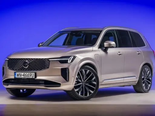 Eleganckie, nowe Volvo w kolorze szampańskim prezentuje się imponująco na tle niebieskiego tła.