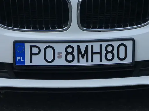 Tablice rejestracyjne sprawdzanie: polskie PO-8MH80 na białym samochodzie.