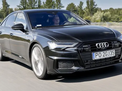 Czarny Audi A6 z silnikiem 3.0 TFSI pędzi autostradą, kierowca skupiony na drodze.