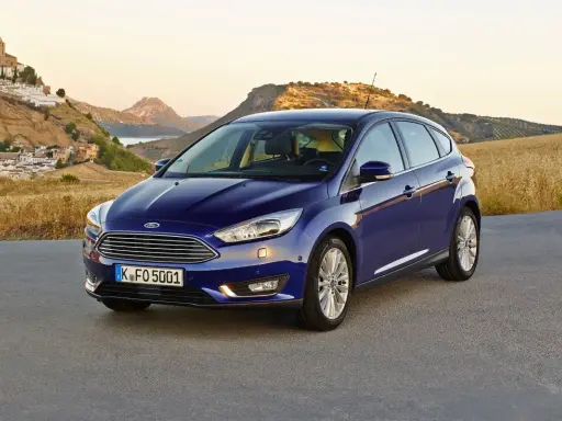 Niebieski Ford Focus MK3 1.6 TDCI na tle malowniczej hiszpańskiej wioski i gór.