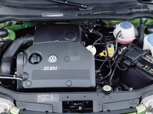 Silnik SDI Volkswagena, z widocznym logo i oznaczeniem, otoczony zieloną komorą silnika, akumulatorem i płynami eksploatacyjnymi.