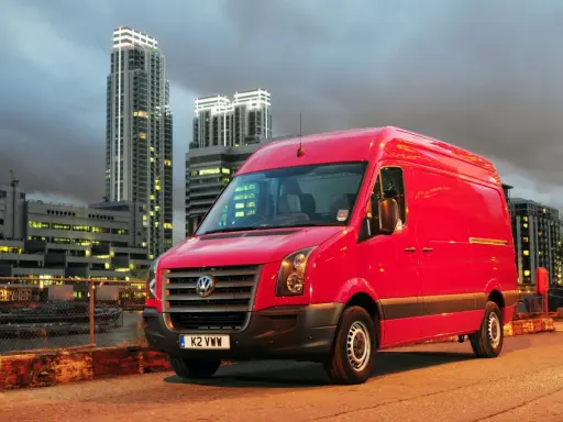 Czerwony Volkswagen Crafter 2.5 TDI na tle nocnego miasta.