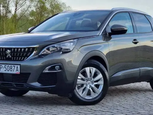 Szary Peugeot 3008 używany z salonu, z polskimi tablicami RP 5087A, zaparkowany na kostce brukowej.