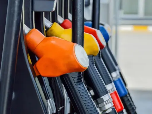 Kolorowe pistolety na stacji paliw, gotowe do tankowania. Jeden z nich, pomarańczowy, sugeruje, że można nim nalać verva diesel.