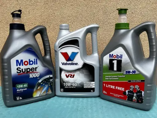 Trzy butelki oleju silnikowego: Mobil Super 1000, Valvoline VR1 i Mobil 1. Idealne do Twojego samochodu, czy to benzyna, czy olej napędowy.