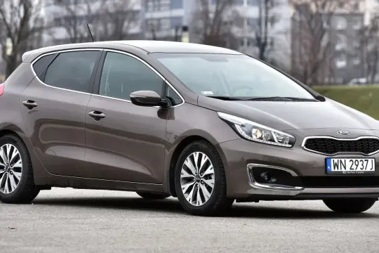 Brązowa Kia Ceed 2016 z chromowanymi detalami i felgami stoi na ulicy.