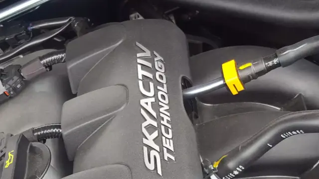 Silnik SKYACTIV TECHNOLOGY, jeden z najlepszych silników benzynowych, z widocznymi przewodami i złączkami.