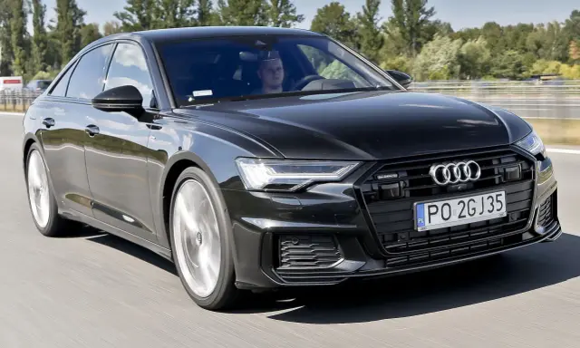 Czarny Audi A6 z silnikiem 3.0 TFSI pędzi autostradą, kierowca skupiony na drodze.