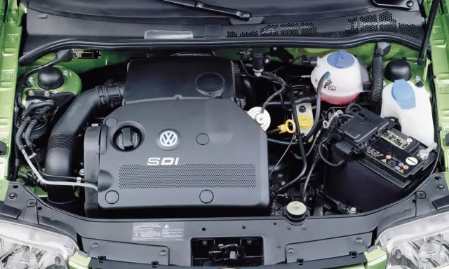 Silnik SDI Volkswagena, z widocznym logo i oznaczeniem, otoczony zieloną komorą silnika, akumulatorem i płynami eksploatacyjnymi.