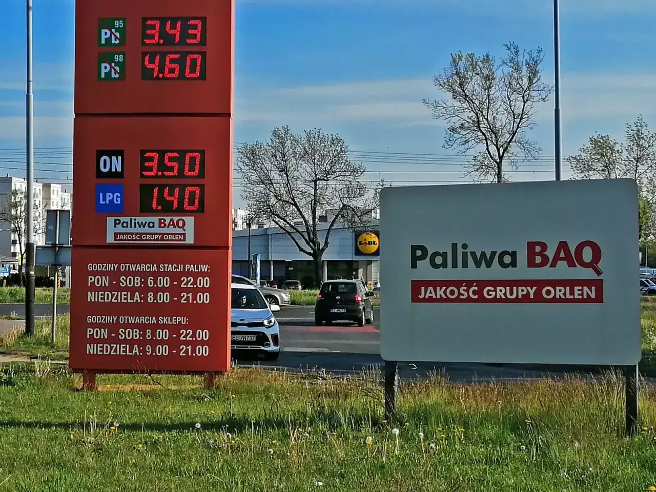 Czerwony słup z cenami paliw: LPG 1.40, ON 3.50. Znak "Paliwa BAQ".