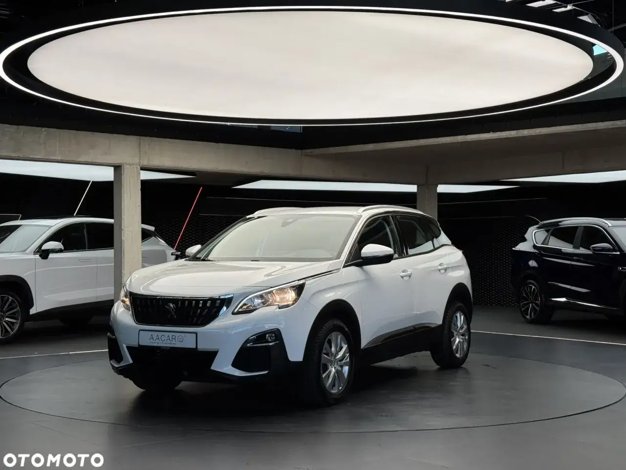 Biały Peugeot 3008 używany z salonu, prezentowany na obrotowej platformie. Idealny wybór dla szukających pewnego auta.