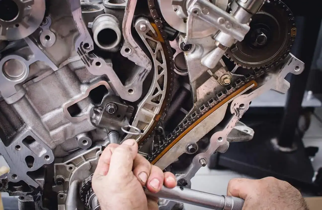 Mechanik pracuje przy rozrządzie silnika. Wymiana poduszki silnika może być konieczna, gdy pojawią się objawy takie jak wibracje.
