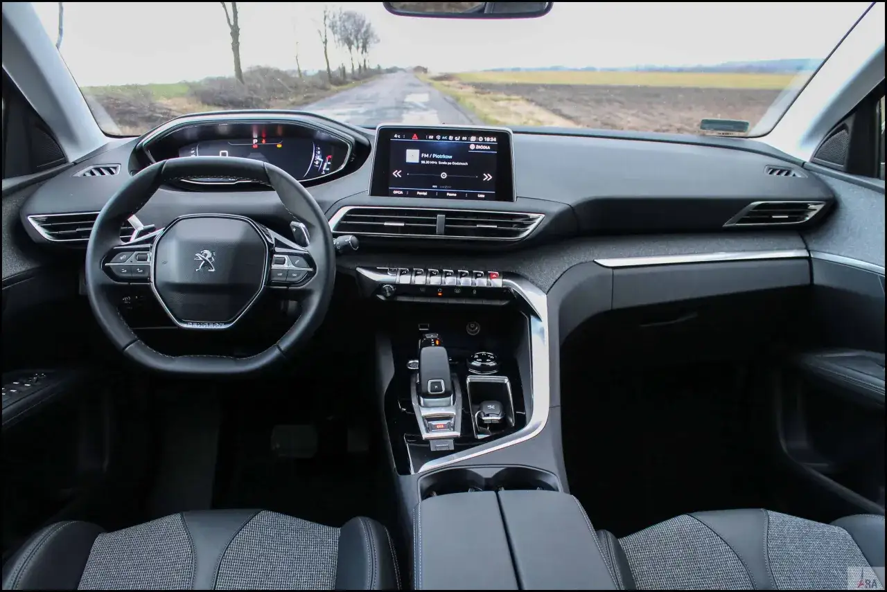 Wnętrze Peugeot 3008 1.6 HDI. Widok na deskę rozdzielczą, kierownicę i ekran multimedialny.