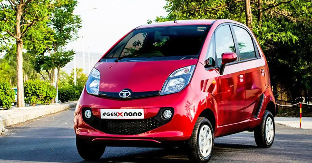 Czerwony Tata Nano z napisem #GENxNANO na grillu, zaparkowany na tle zieleni.