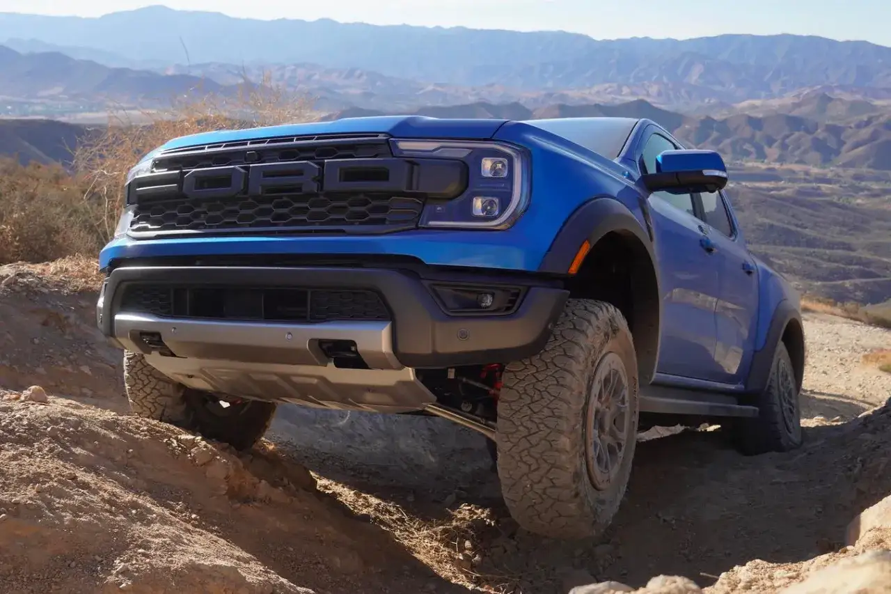 Niebieski Ford Ranger Raptor pokonuje wyboisty teren, gotowy na każde wyzwanie.