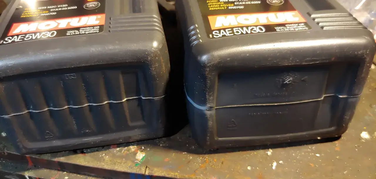 Olej Motul 5W30 butelki i silnik samochodu