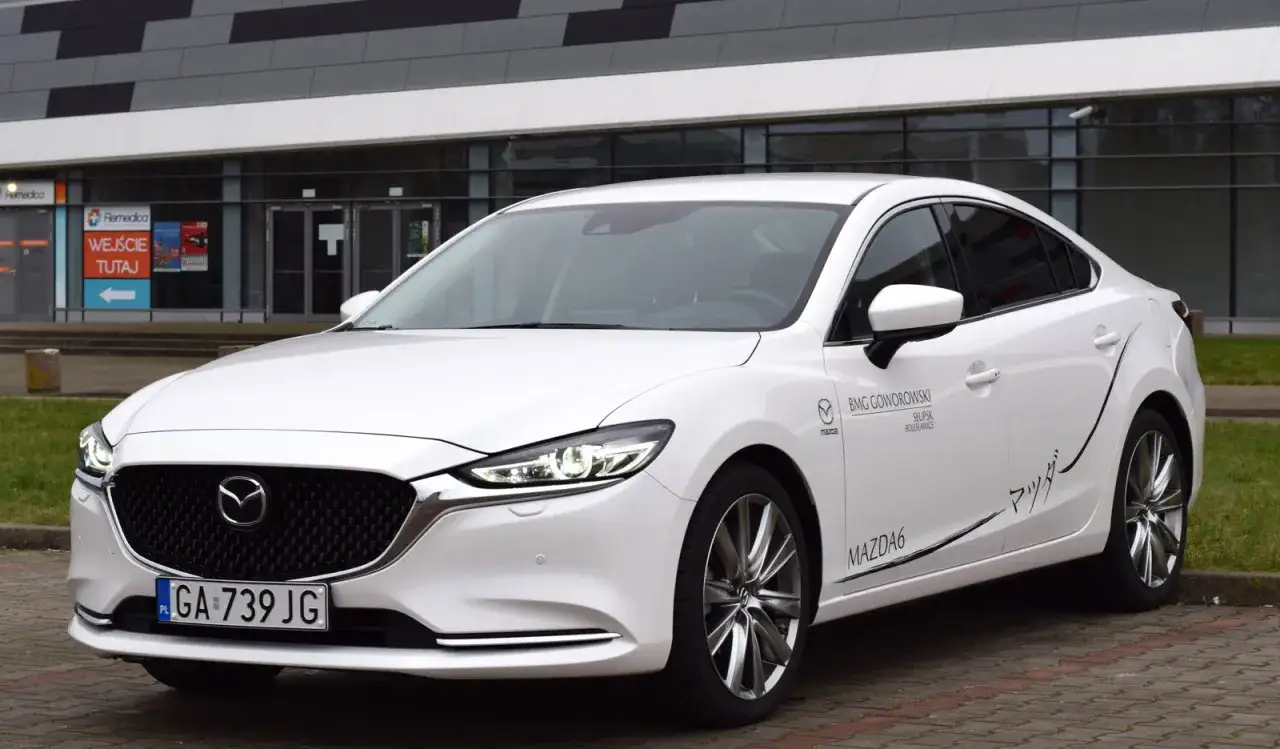 Biała Mazda 6 2.5 benzyna z napisem