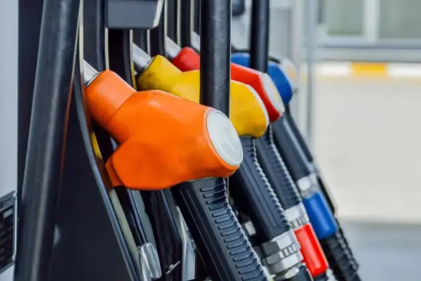 Kolorowe pistolety na stacji paliw, gotowe do tankowania. Jeden z nich, pomarańczowy, sugeruje, że można nim nalać verva diesel.
