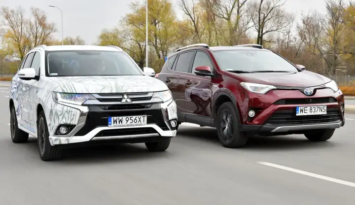 Dwa SUV-y, biały Mitsubishi Outlander i czerwony Toyota RAV4, jadące po drodze. Idealne dla szukających najmniej awaryjne SUV-y 10 letnie.